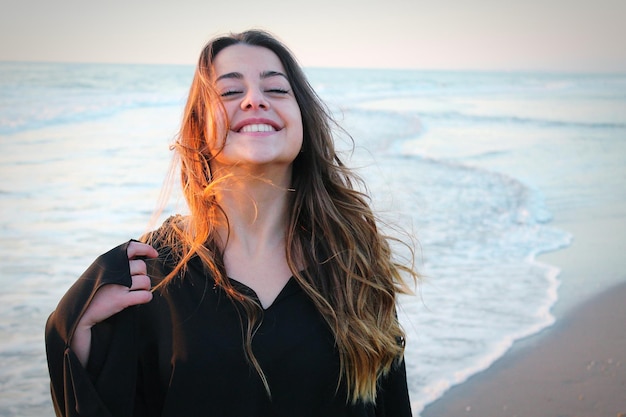 Foto close-up di una donna felice in piedi sulla riva della spiaggia