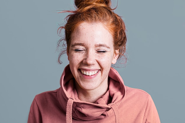 Close-up happy woman with pink hoodie and grey background