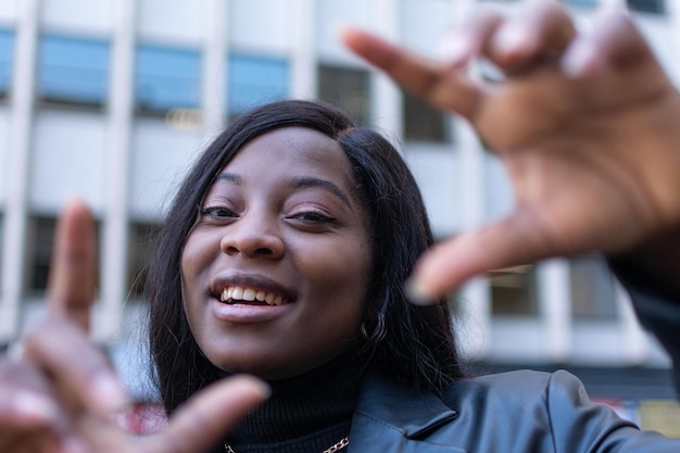 Close up of happy young girl showing frame with fingers