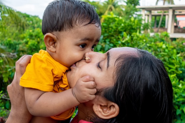 Close up of happy young south Asian mother hugging cuddling little infant A toddler and mom love smiling Small baby enjoying the tender family moment Motherhood and child care concept