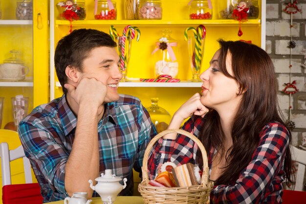 Close up Happy Young White Couple in Casual Outfits Looking Each Other with Hands on their Face While Having a Date at the Cafe.