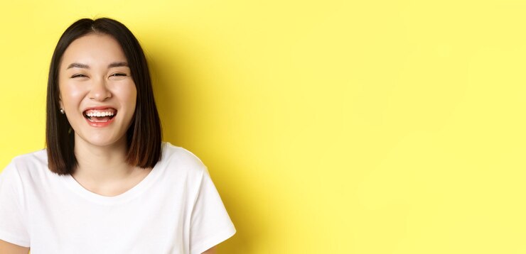 Photo 白い t シャツに屈託のない立っている笑顔と笑いを楽しんで幸せな若い女のクローズ アップ