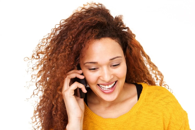 Close up happy young woman talking on cell phone against isolated white background