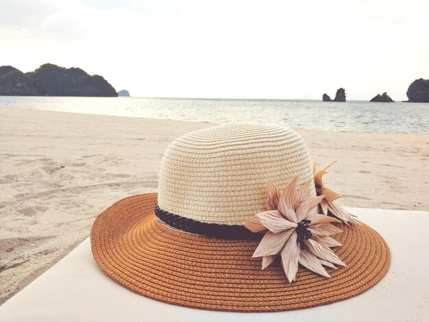 Foto close-up di un cappello sulla spiaggia contro il cielo