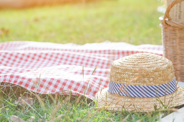 Close-up of hat and picnic basket on grassy field