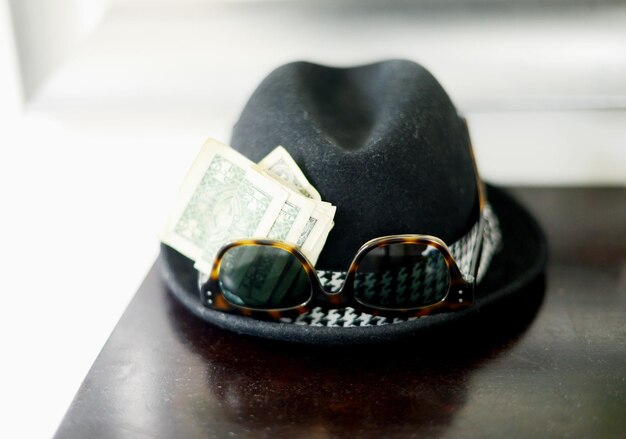 Close-up of hat with sun glasses and money