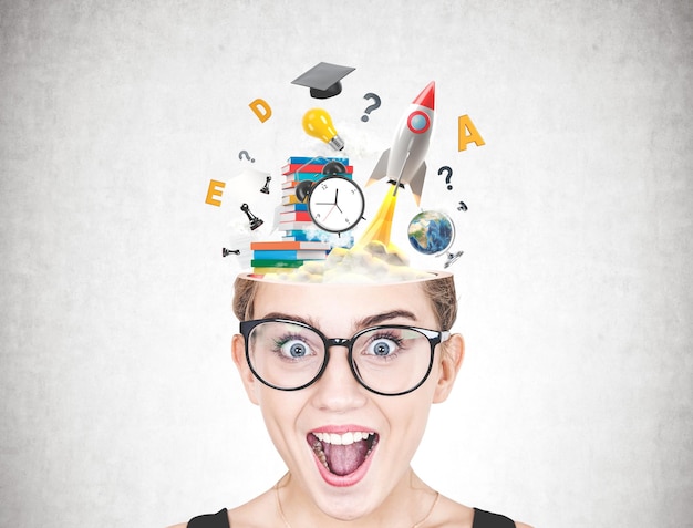 Close up of a head of an astonished young woman wearing glasses against a concrete wall with a colorful start up launch sketch on it.