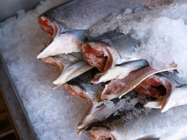 Крупный план головы срезанного свежего лосося со льдом на свежем рынке