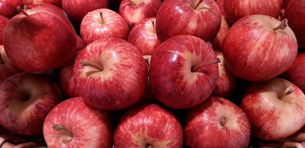 Крупный план кучи многих красных яблок. Абстрактный фон красочных и здоровых фруктов.
