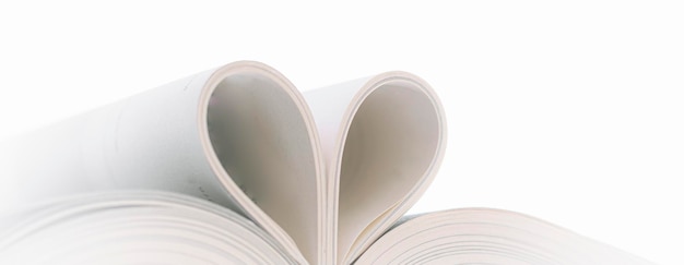 Foto close-up di una forma di cuore su un libro su uno sfondo bianco