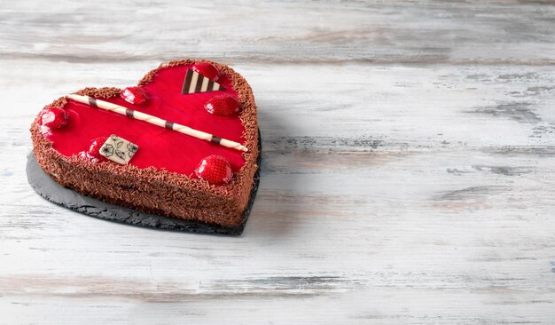 Foto close-up di una torta a forma di cuore su un tavolo di legno