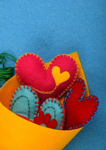 Photo close-up of heart shape decorations in yellow fabric against blue floor