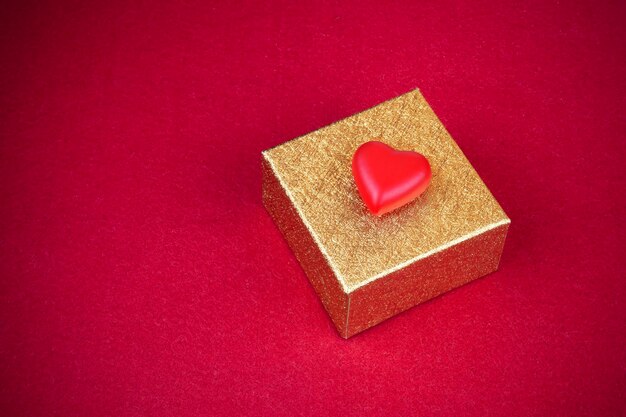 Photo close-up of heart shape and gift on red background