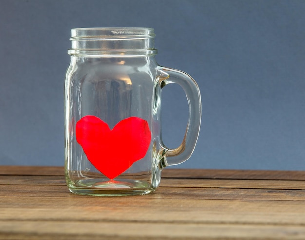 Photo close-up of heart shape on glass mason jar against wall