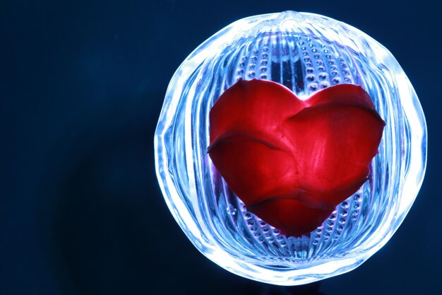 Photo close-up of heart shape glass on table against black background