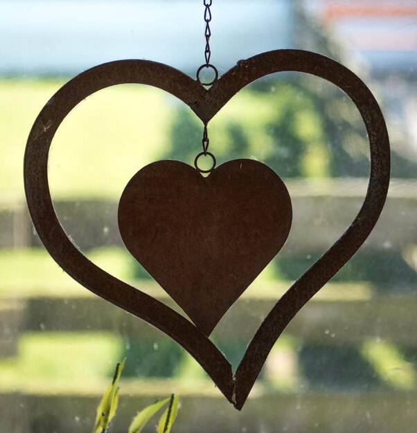 Close-up of heart shape hanging against sky