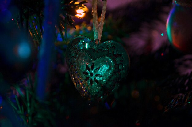 夜にクリスマスツリーにぶら下がっているハートの形のクローズアップ