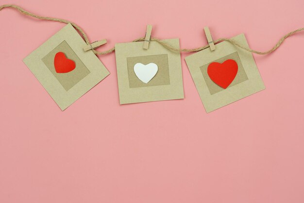 Foto close-up di forma di cuore appeso su carta rosa contro la parete