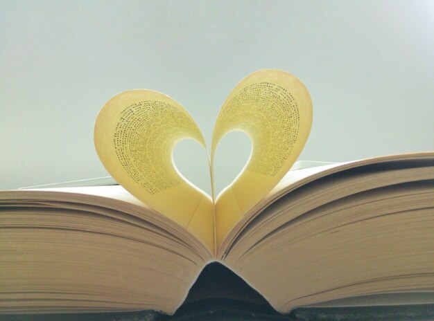 Foto close-up di forma di cuore realizzato da pagine su sfondo bianco