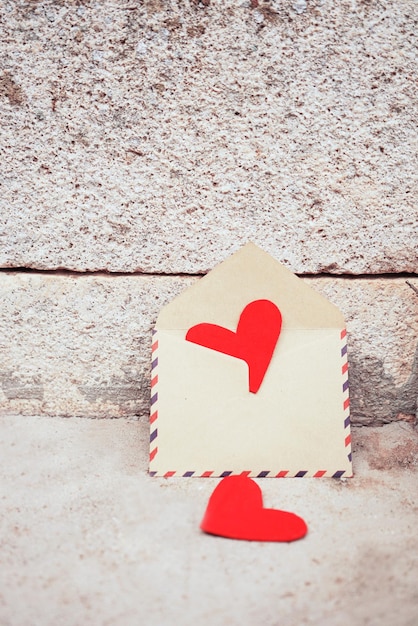 Photo close-up of heart shapes and envelops against textured wall