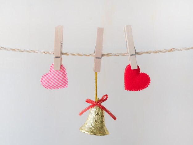 Photo close-up of heart shapes hanging on rope against white background