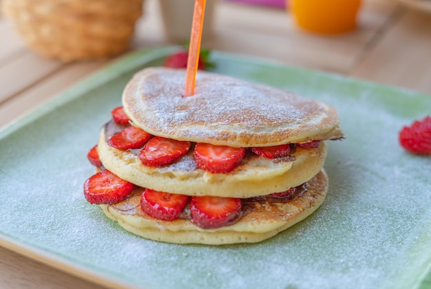 Close-up heerlijke pannenkoeken met verse aardbeien en chocoladesaus. Ontbijtconcept.