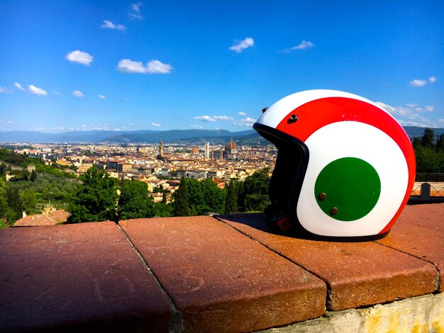 Photo close-up of helmet on retaining wall against sky