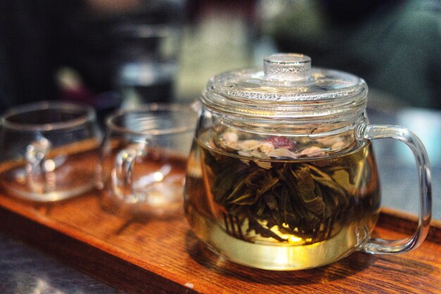 Close-up of herbal tea in glass teapot on table