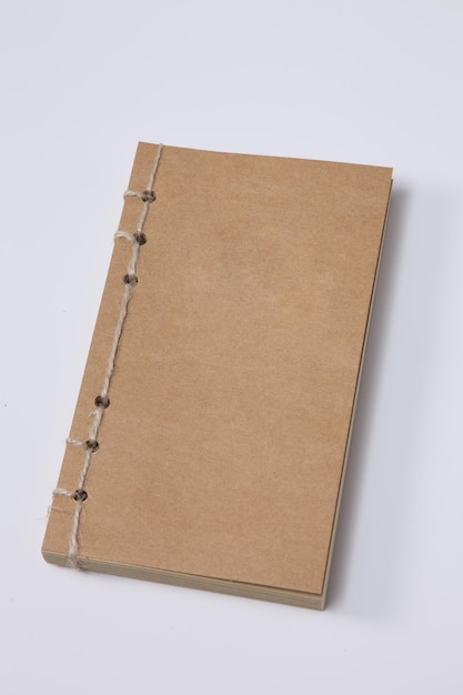 Close-up high angle view of closed brown book over white background