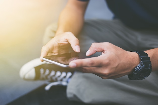 Primo piano delle mani dell'uomo hipster con il cellulare