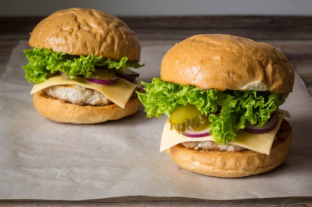 Close-up of home made tasty burgers on wooden table.