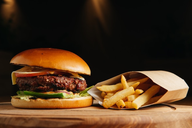 Close-up of home made tasty classic burger with french fries on wooden table