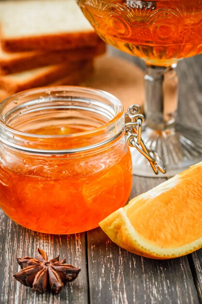 Close up of homemade orange jam in glass jar on table