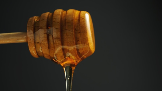 Photo close-up of honey dipper against black background