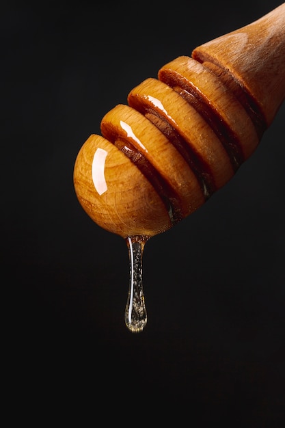 Close up honey dripping off dipper