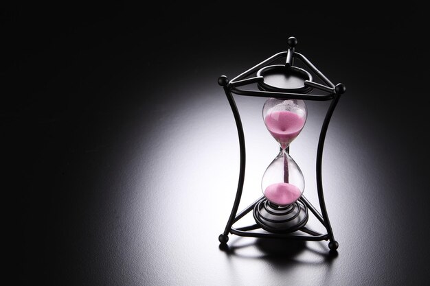 Photo close-up of hourglass over black background