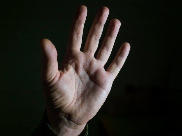 Close-up of human hand against black background
