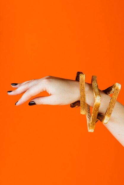 Close-up of human hand against orange wall