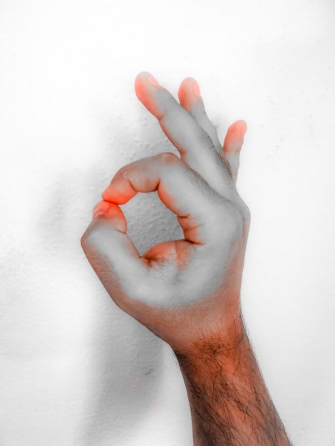 Photo close-up of human hand against white background in  silver paint