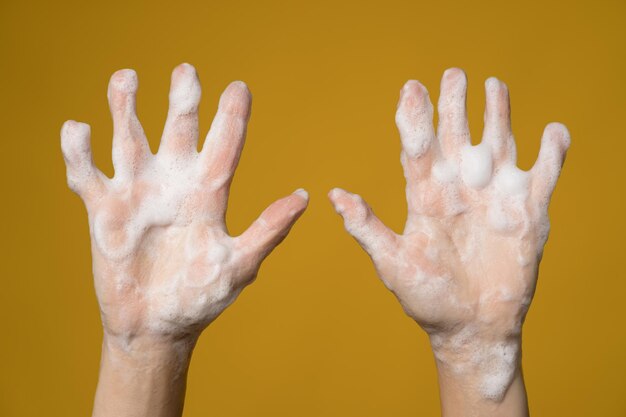 Close-up of human hand against yellow background