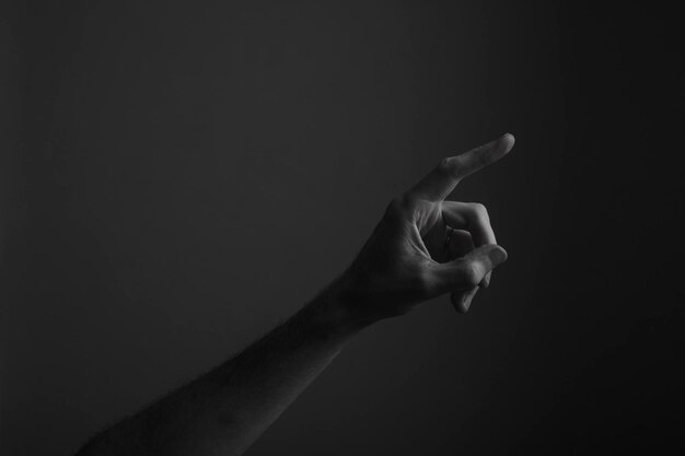 Photo close-up of human hand gesturing against black background