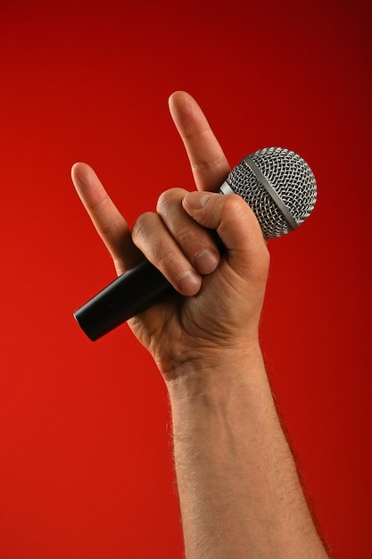 Photo close up of human hand holding a mic