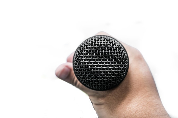 Close-up of human hand holding microphone against white background