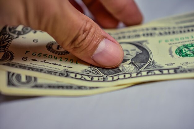 Close-up of human hand holding paper currencies on table