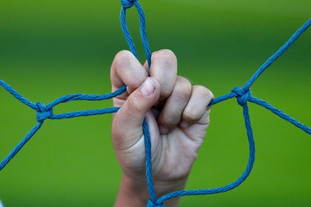 Foto close-up di una mano umana che tiene la corda