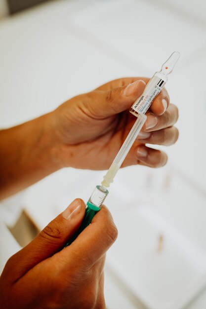 Photo close-up of human hand holding syringe