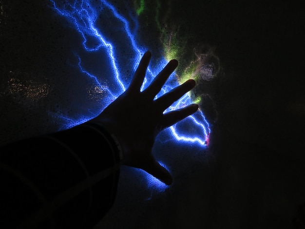 Photo close-up of human hand on illuminated light