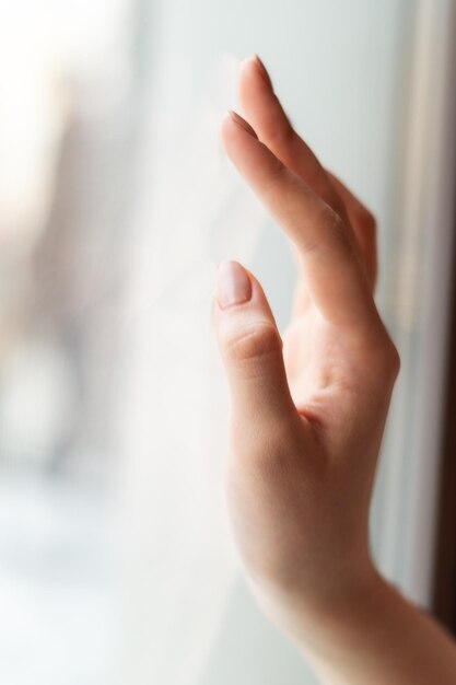 Photo close-up of human hand on window