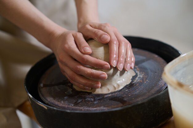 Close up of human hands molding clay on a pottery wheel