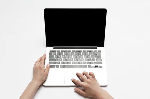 Photo close up of human hands using laptop isolated on white background. top view. copyspace, blank screen. surfing, online shopping, scrolling, betting, working. education and business concept.